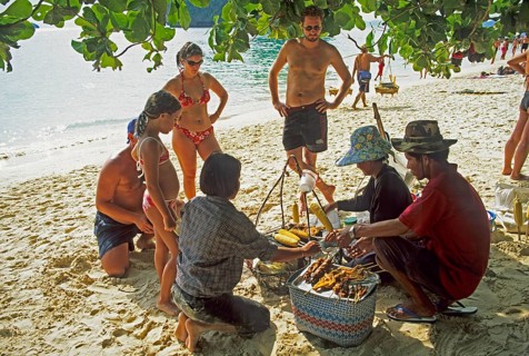 Woman with food store and customers on Pranang Cave beach, two years in front of the tsunami,