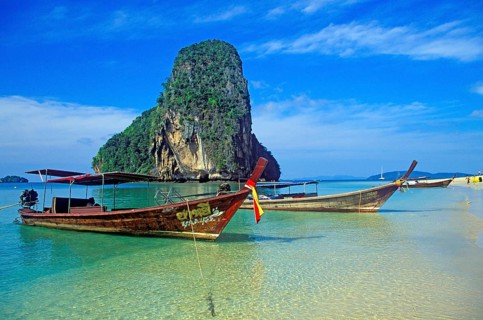 Rocks in the sea and longtail boats on Pranang Cave beach, two years in front of the tsunami,