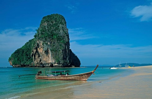 Rocks in the sea and longtail boat on Pranang Cave beach, two years in front of the tsunami, Krabi,