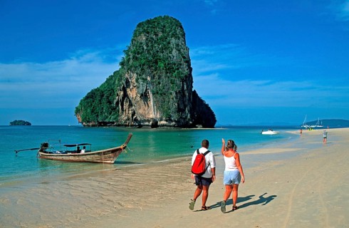 People, rocks in the sea and longtail boat on Pranang Cave beach, two years in front of the