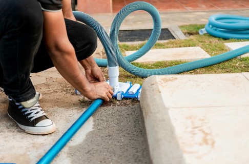 Pool suction hose installation. Person connecting pool hose handle. Man connecting the handle on
