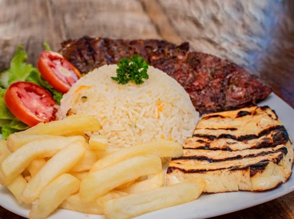 Close-up of roast beef with tomato salad and french fries, traditional barbecue roast beef food