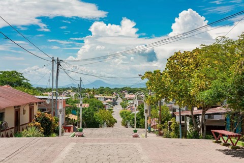 Streets of Nagarote with a view of the momotombo volcano on a suny day. View of the streets of