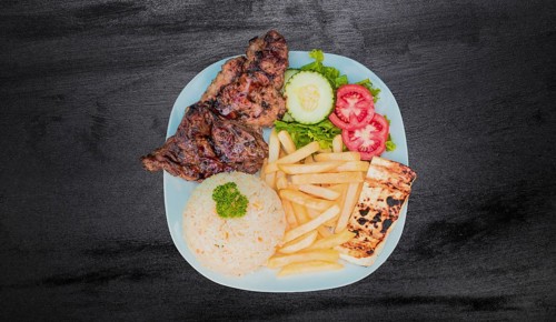 Plate of roasted chicken with rice and french fries on wooden table, Top view of plate of roasted
