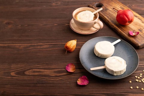 ?hocolate Ice cream in white glaze, cup of coffee, on brown wooden background, side view, copy