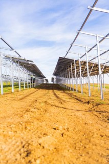Straight rows of metal structures under blue sky, Energiewende, construction of PV open space,