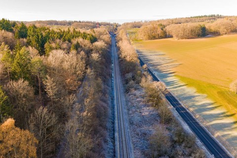 Railway line between trees and a country road surrounded by nature, construction of the Hermann