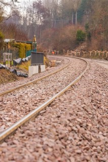 Railway tracks on a bend surrounded by gravel, along a wintry landscape, construction of the