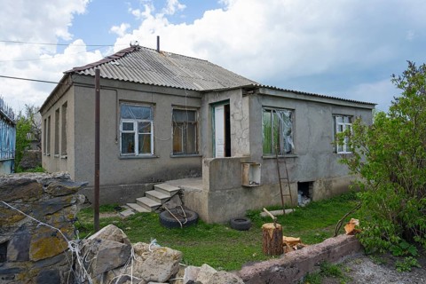 Abandoned house with damaged windows and brick walls in a rural area, inhabited house, Sameba,