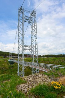 A modern suspension bridge over a green landscape with wildflowers, diamond bridge, Diamond Glass