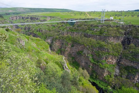 Suspension bridge stretches over a deep, green gorge with surrounding nature, Diamond Bridge,
