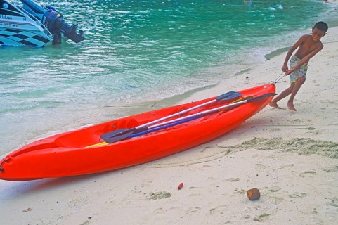 Boy pulls a kayak on the beach of Ko Phi Phi Don, two years in front of the tsunami, Thailand,
