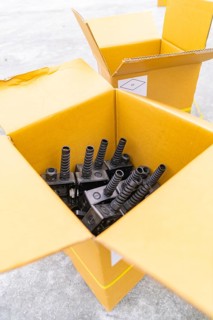 Open boxes with black charging stations inside, parking garage construction with charging