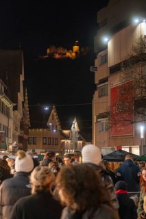 Nighttime scene with crowd and illuminated castle in the background, Weihnachtsmark Nagold,