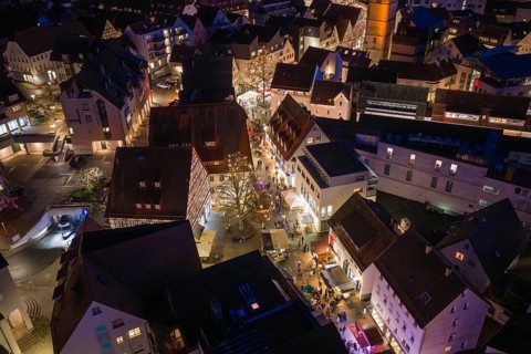 Illuminated streets and buildings of a city in a nocturnal, wintery atmosphere, Weihnachtsmark