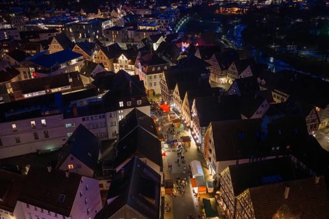 Aerial view of an atmospheric city at night with illuminated streets and houses, Weihnachtsmark