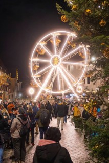 Illuminated Ferris wheel with people at a Christmas market in a festive atmosphere, Weihnachtsmark