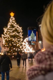 A Christmassy tree is photographed by a person with a mobile phone, Weihnachtsmark Nagold,