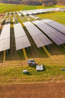Workers install solar panels in fields with agricultural technology, energy transition,