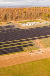 Large solar fields next to a forest area in autumn, energy revolution, construction of PV open