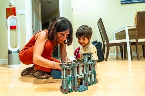 Mother and son enjoying quality time together, building a toy house in the comfort of their living