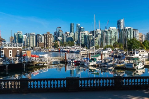 Modern buildings of vancouver reflecting in the calm waters of coal harbour, with yachts and