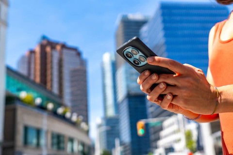 Tourist using a smartphone while surrounded by the vibrant downtown of vancouver, british columbia,