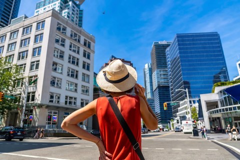 Young woman wearing a straw hat enjoying the cityscape of vancouver, british columbia, on a vibrant