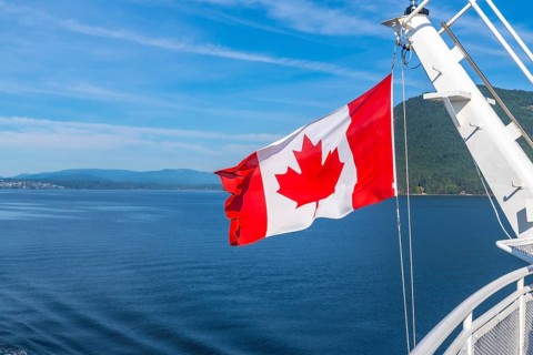 Canadian flag waving in the wind on a ferry sailing from victoria, vancouver island, to vancouver,