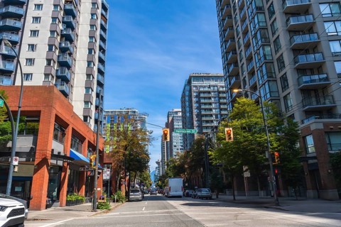 Modern residential and commercial buildings line a busy street in vancouver, british columbia, with
