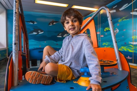 Young boy playing on a colorful play structure aboard a ferry from victoria to vancouver, with a