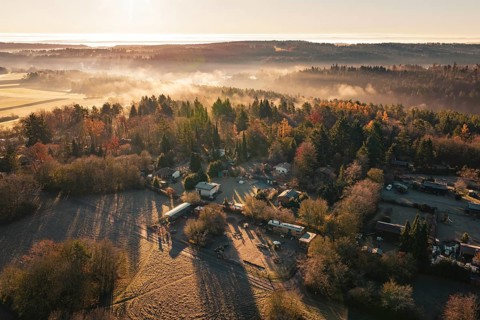 Snowy village surrounded by thick forests with fog and sunrise over the hills, Gechingen, Calw