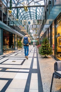 Person in modern shopping arcade with Christmas decoration and festive atmosphere, Calwer Passage,