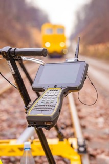 A technical device with a screen on a rail surveyor in the blur of the background, stuffing machine
