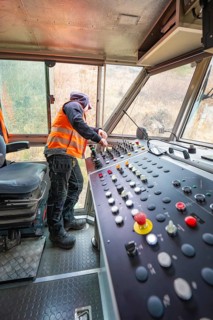 Working area in the driver's cab of a track construction vehicle with control panel, tamping