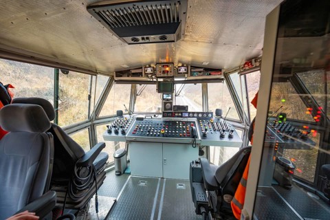 Panoramic view of the cockpit of a track construction device with various controls, tamping machine