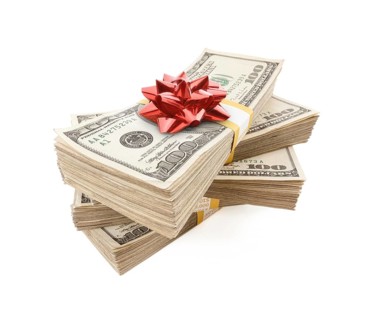 Stacks of one hundred dollar bills with red bow on top