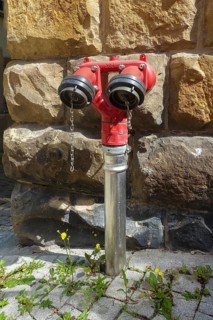 Hydrant, red faucet for extracting water, back masonry, paving stones, Tübingen, Baden-Württemberg,