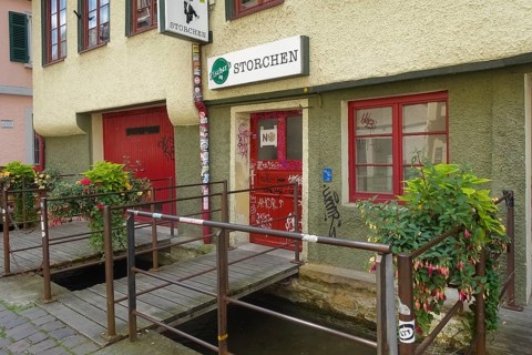 Pub, stork, traditional restaurant, beer pub on the river Ammer, red front door, graffiti, bridge,