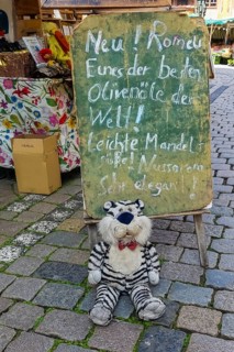 Blackboard, chalk script, funny advertisement, letters, market scene, stuffed tiger, plush toy with