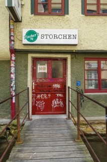 Pub, stork, traditional restaurant, beer pub on the river Ammer, red front door, graffiti, bridge,