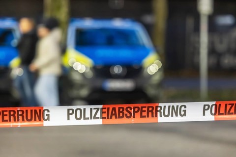 Flutter tape with the inscription police barrier. Behind it, a police car. Stuttgart,