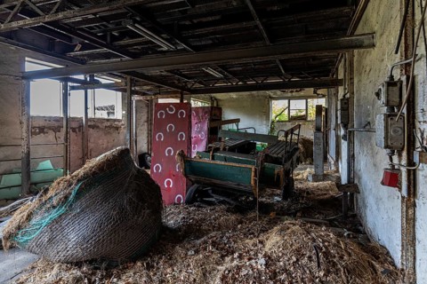 Old building with straw and equipment, dilapidated plant of a former agricultural production