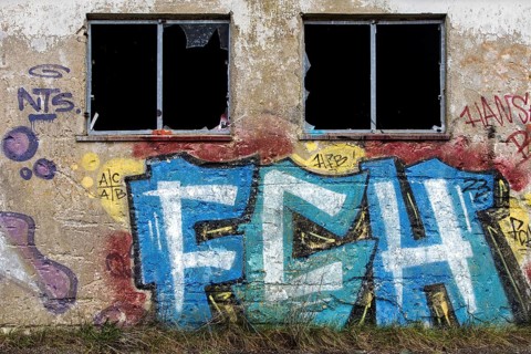 Grafity on an old wall, dilapidated plant of a former agricultural production cooperative of the