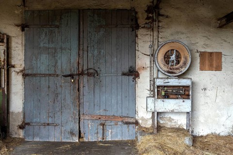 Building with wooden gate and old scale, dilapidated plant of a former agricultural production