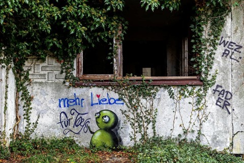 Grafity on an old house wall, dilapidated plant of a former agricultural production cooperative of