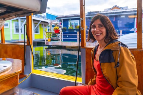 Happy tourist smiling while enjoying a sunny summer day on a small boat trip visiting the colorful