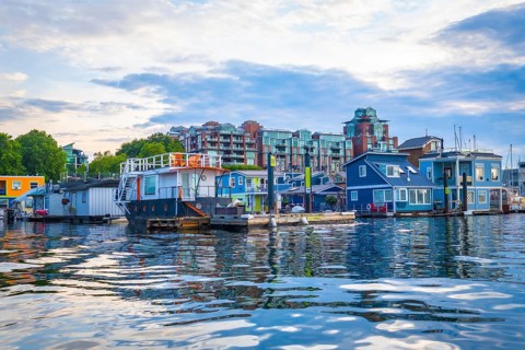 Colorful floating homes reflecting in the calm waters of fisherman's wharf park in victoria,