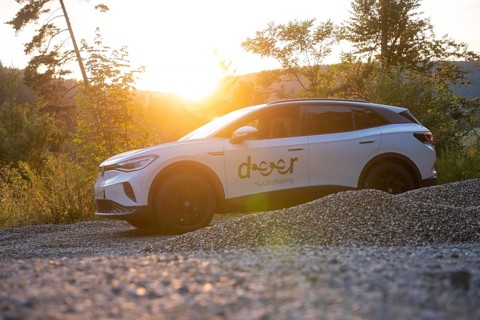 White car on gravel under the evening sun, surrounded by nature, quiet atmosphere, VW ID4 electric