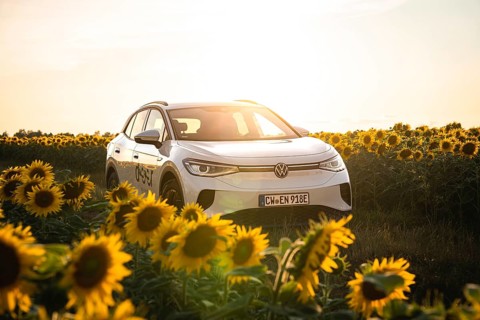 A white car is placed in sunflowers at sunset, VW ID4 electric car, Deer Carsharing, Calw, Germany